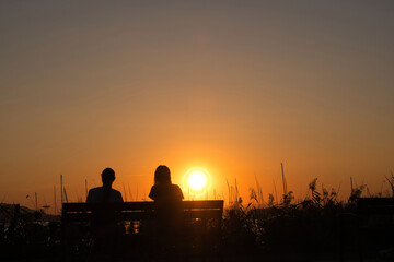 Zwei Frauen betrachten den Sonnenuntergang am Bodensee