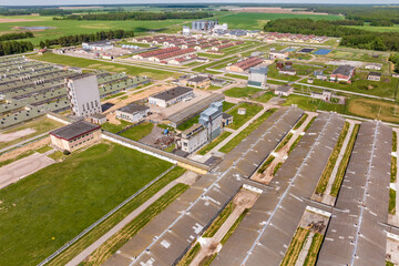 aerial panoramic view over livestock farm and agro-industrial complex with silos and rows of barns, pigsties, chicken coops..