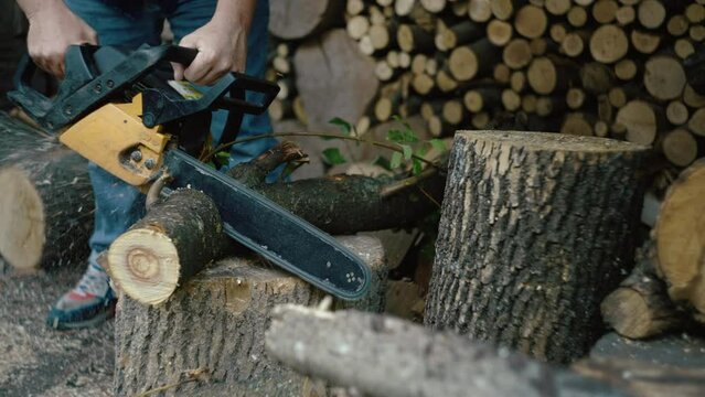 A man cuts a tree with a chainsaw to run home. A tree blank for chopping with an ax. High quality 4k footage