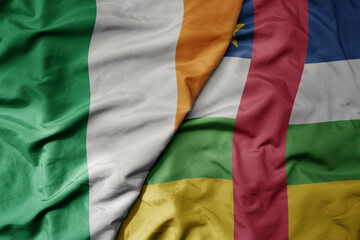 big waving national colorful flag of ireland and national flag of central african republic .