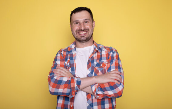 Photo of attractive charming young guy wear white t-shirt arms crossed empty space isolated yellow color background.