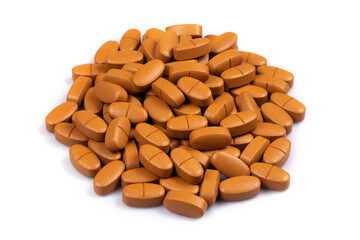 Close-up of a pile of white brown pills on isolated white background. Selective Focus.