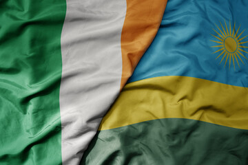 big waving national colorful flag of ireland and national flag of rwanda .