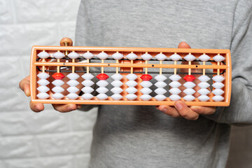 Child boy with Japanese traditional abacus soroban on white background. Child using abacus. math Education and development concept. mental mathematics, arithmetic