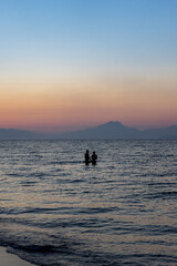 zwei silhouetten im Meer bei Sonnenuntergang 