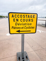 French "docking in progress, pedestrian and cyclist diversion" sign on the quays of Bordeaux, France