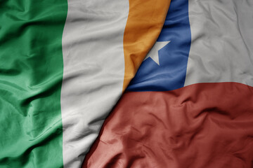 big waving national colorful flag of ireland and national flag of chile .