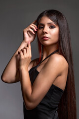 Obraz premium Portrait of a young brunette girl with exquisite beautiful makeup with her hands in a frame