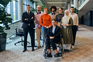 Fototapeta premium In a spacious and modern startup office, a diverse group of business colleagues, including a colleague in a wheelchair, collaborates and interacts, exemplifying inclusivity, diversity, and teamwork in