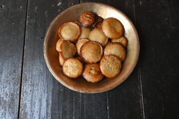 Traditional snacks and sweets of India.  It is made by mixing rice flour and jaggery and frying it in oil. Indian holy offerings. It is made during festivals. Indian food. 