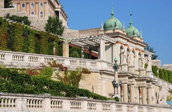 Exterior view of the Neorenaissance Castle Garden Bazaar (V&aacute;rkert Baz&aacute;r) in Budapest, Hungary, Europe. Statues, ornaments, columns, and turquoise domes of the historical building on Ybl Mikl&oacute;s Square.