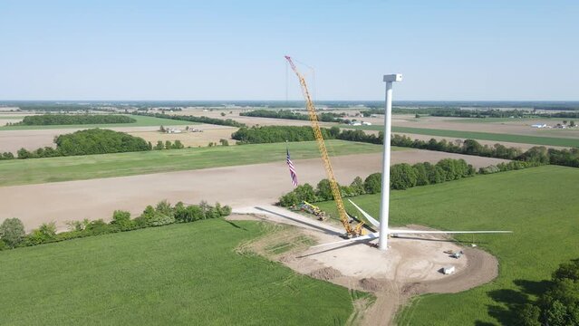 USA flag wave in construction site of wind turbine, aerial view