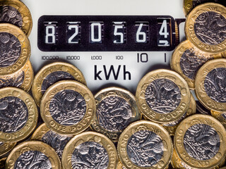 Electricity meter and kWh symbol surrounded with one pound coins. Concept for energy supplier, high bills, price rise, cost of living, inflation and expensive fuel.