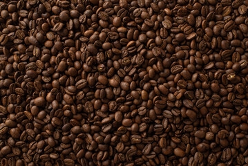 Coffee Fiesta: Top-down view shot of a profusion of scattered roasted coffee beans, forming a captivating backdrop for text or marketing