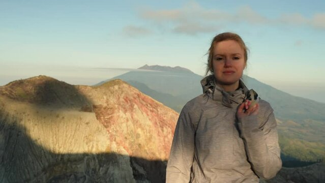 Cute caucasian woman with gas mask enjoys view of Indonesian volcano in Java