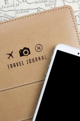 travel journal cover adorned with three small logos: a plane, a camera, and a compass, alongside a smartphone. The combination of these iconic symbols evokes a sense of adventure and exploration.