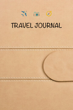 close-up of a travel journal cover featuring three small logos: a plane, a camera, and a compass. The logos add a touch of adventure and exploration to this beautifully crafted journal