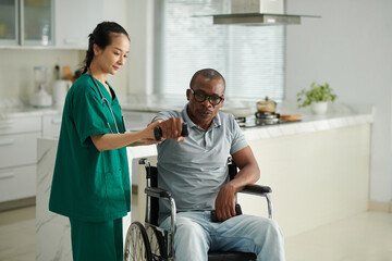 Fototapeta premium Physiotherapist asking patient with disability to outs the next arm with dumbbell