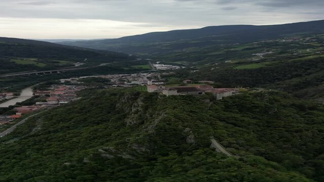 Klausen, Italy - 4K flying above Saben Abbey (Monastero di Sabiona) by Chiusa (Klausen) commune northeast of the city of Bolzano and South Tyrol Dolomites at the background on a cloudy summer day