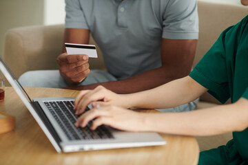 Caregiver helping patient to pay medical bills with credit card online