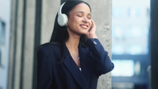 Portrait of successful inspired businesswoman with headphones listen to music and relaxing in the modern city centre Pretty young woman entrepreneur looking ahead outdoors alone