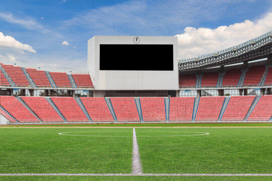 Football field with large LED screen in stadium with empty seats, scoreboard.