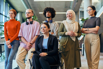 Fototapeta premium In a spacious and modern startup office, a diverse group of business colleagues, including a colleague in a wheelchair, collaborates and interacts, exemplifying inclusivity, diversity, and teamwork in