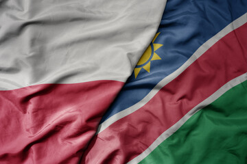 big waving national colorful flag of poland and national flag of namibia .