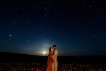 silhouettes of a couple in love at night against the backdrop of the night starry sky, romantic date