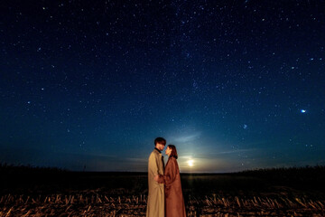 silhouettes of a couple in love at night against the backdrop of the night starry sky, romantic date