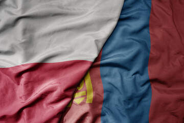 big waving national colorful flag of poland and national flag of mongolia .