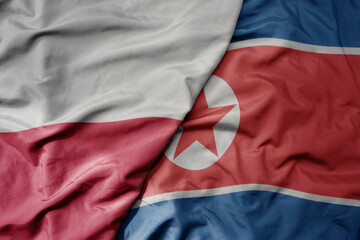 Fototapeta premium big waving national colorful flag of poland and national flag of north korea .