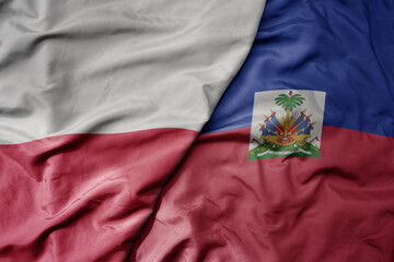 big waving national colorful flag of poland and national flag of haiti .