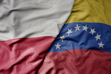 big waving national colorful flag of poland and national flag of venezuela .