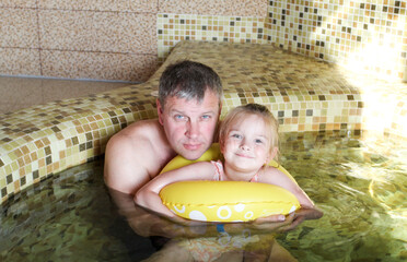 Father and daughter on an inflatable ring