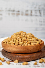 Dried mulberries in wooden bowl. Sun-dried mulberry on a white wood background. Close up