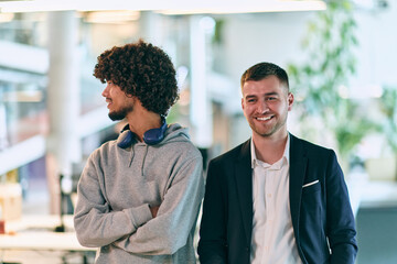 In a modern startup office setting, a business director and a young African American entrepreneur sit surrounded by their colleagues, embodying diversity and teamwork in the corporate world.