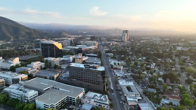 Aerial stock drone footage of Burbank, California flying towards Warner Bros and Universal Studios at sunset