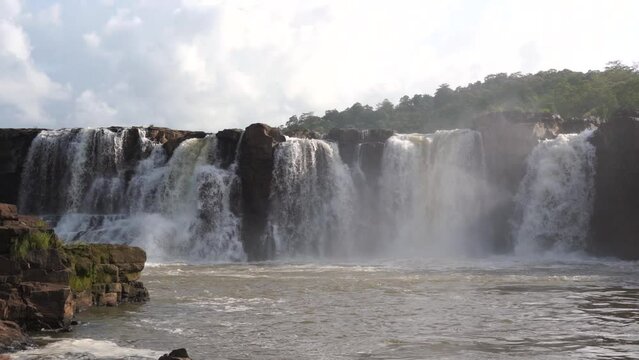 Beautiful slow-motion movie of a large waterfall with pouring water over rock.