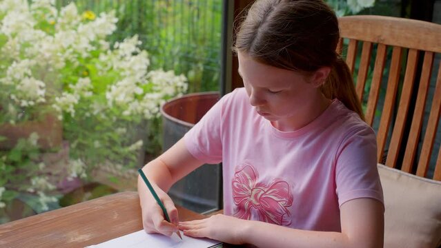 Teenage girl draws with a pencil