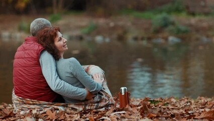 Hello autumn. happy stylish family in the park with thermos embracing.