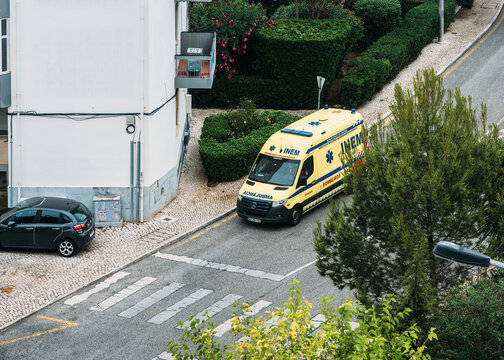 Cascais, Portugal - September 8, 2023: An ambulance belonging to INEM parked on a residential street with sirens flashing