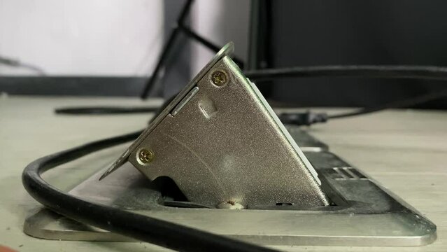 Male hand unplug from floor box outlet socket power supply appliance close up view. Energy saving concept