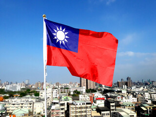 The flag of Taiwan flutters in the sky. 26th floor rooftop cityscape in Kaohsiung, Taiwan.