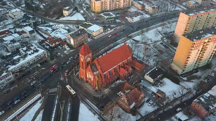 Aerial of Gothic Brick Church Surrounded by Blocks of Flats in Winter