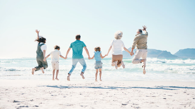 Jump, energy and holding hands with big family on the beach for support, summer vacation and travel. Freedom, health and love with people on seaside holiday for adventure, trust or happiness together