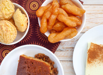 Traditional South African sweet food on rustic wood with traditional printed cloth. Milk tart, koek...