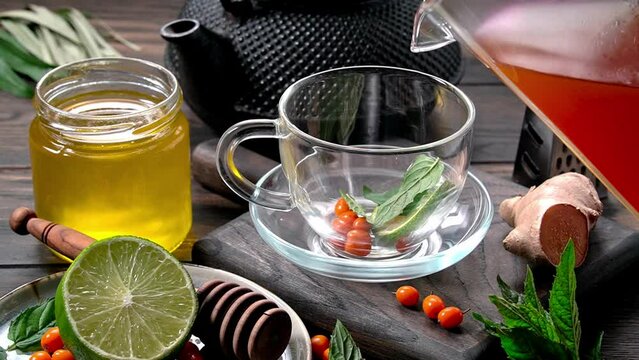 Pouring sea buckthorn tea with llime, honey, ginger and mint