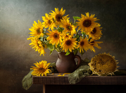 Still life with a bouquet of sunflowers on an old wooden table