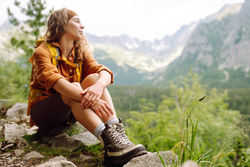 Hiking boot. Close-up of female legs in hiking boots on a hiking trail, on top of a mountain...